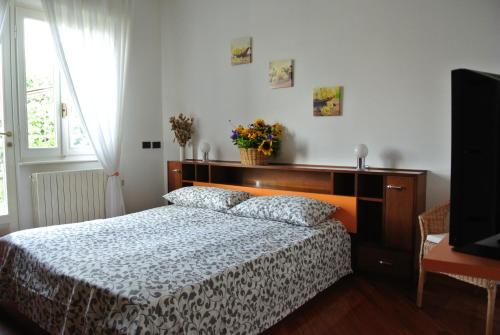Schlafzimmer mit einem Bett mit einem Kopfteil aus Holz in der Unterkunft B&B SARI in Como