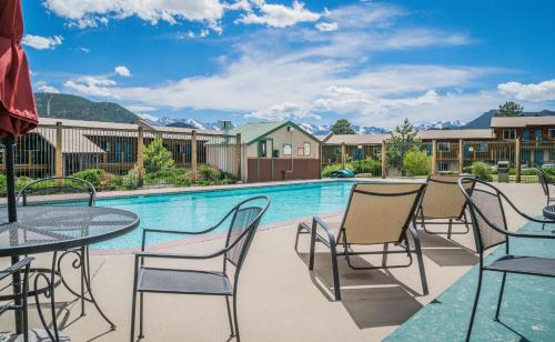 a patio with tables and chairs next to a swimming pool at Blue Door Inn in Estes Park
