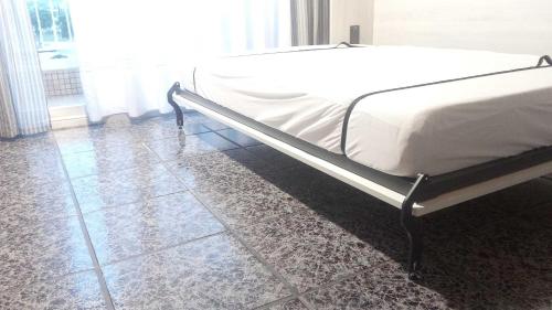 a bed in a bedroom with a tiled floor at R&G Pineda Apartamento in La Pineda