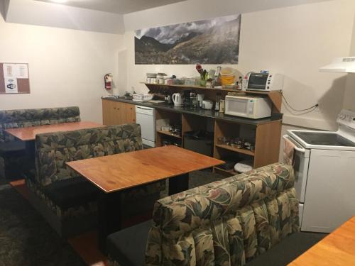 a dining room with a table and a kitchen at Invermere Hostel in Invermere