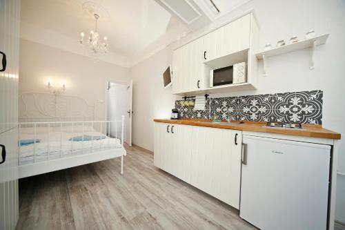 a kitchen with white cabinets and a counter top at Öreg Malom Apartmanház in Bogács