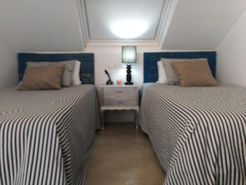 two beds sitting next to each other in a bedroom at Vilna House with private pool, jacuzzi and garden -Optional pool and jacuzzi heating in Agaete