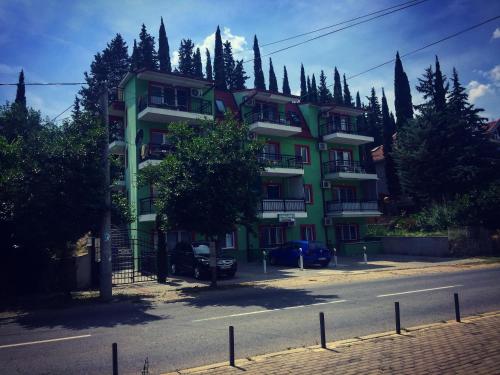 a green building with cars parked in front of it at Apartments Villa Zora in Star Dojran