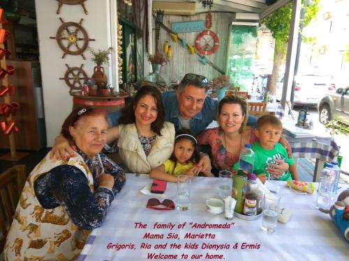 a family posing for a picture at a table at Andromeda Hotel Apartments in Kos Town