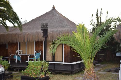 a hut with a table and chairs in front of it at Hotel Casa de Piedra in Coquimbo