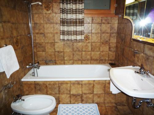 łazienka z wanną, toaletą i umywalką w obiekcie Apartments Ingrid w mieście La Val