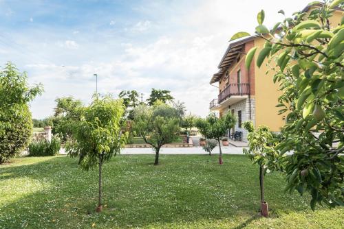 a yard with trees in front of a building at Camere Mariella in Bastia Umbra