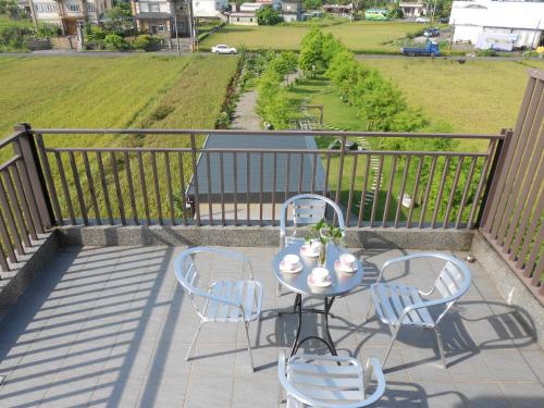 a table and chairs on a balcony with a view at 蘭卡威羅東庭園民宿 in Luodong