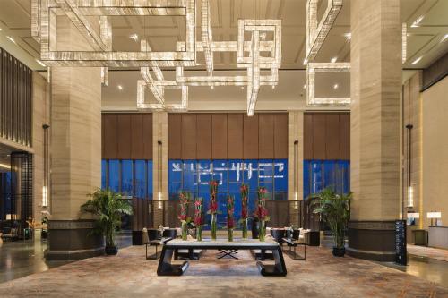 a large lobby with a table with flowers on it at Pullman Hefei Sunac in Hefei