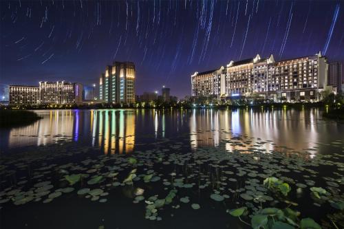 a city skyline at night with a pond with lilies at Pullman Hefei Sunac in Hefei