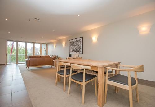 a dining room with a wooden table and chairs at Sullivans Cove Apartments in Hobart