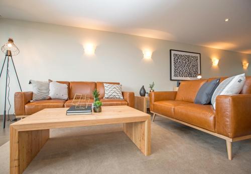 a living room with two couches and a coffee table at Sullivans Cove Apartments in Hobart