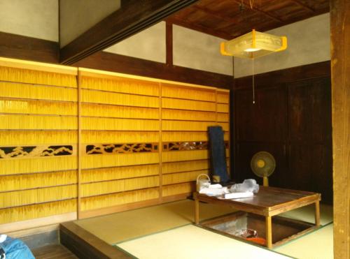 a room with wooden walls and a table in it at Guesthouse Okagesan in Hongu
