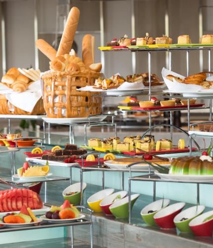 a buffet with many plates of food on display at Novotel Makassar Grand Shayla in Makassar