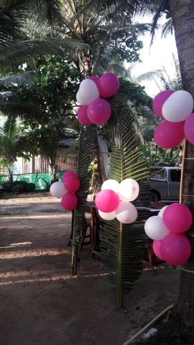 a bunch of pink and white balloons hanging from a tree at Tony Home and Restaurant in Karon Beach
