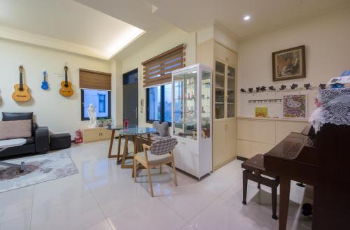 a living room with a piano and a living room with guitars at Guitar Charm B&B in Wujie