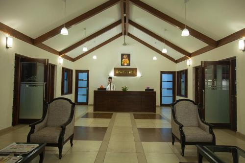 a lobby with two chairs and a reception desk at Le Coffee Resort in Sultan Bathery