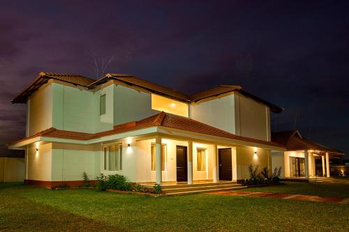 a large white house at night with lights at Le Coffee Resort in Sultan Bathery