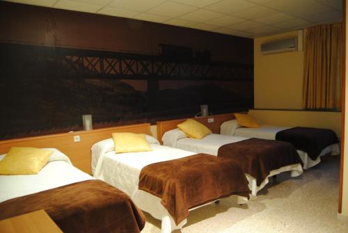 a room with four beds with brown blankets at Guilleumes Montserrat in Monistrol