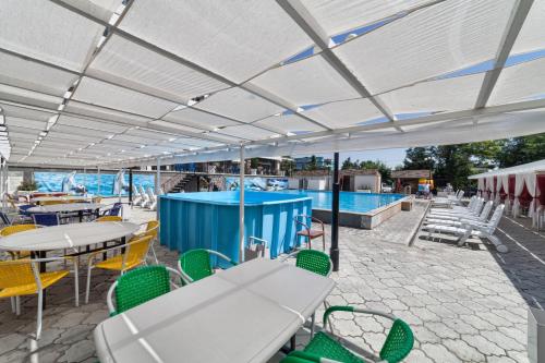 a patio with tables and chairs and a pool at Hotel Osh-Nuru in Osh