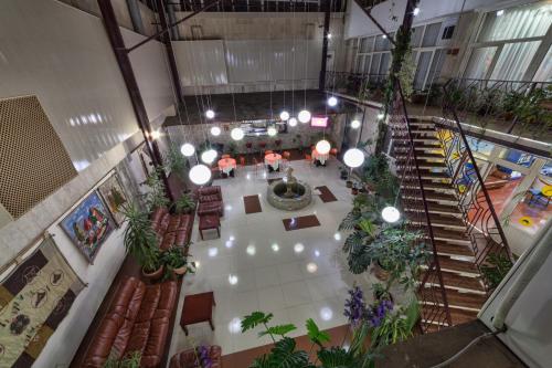 an overhead view of a lobby with plants and stairs at Hotel Osh-Nuru in Osh
