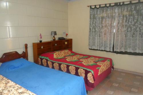 a bedroom with two beds and a window at Quitinetes dos Ipês in Barra de São João