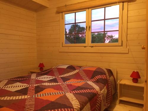 a bedroom with a bed in a room with windows at Kāpas in Melnsils