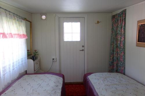 a bedroom with a bed and a window and a door at Karlholm Snatra Stugområde in Karlholmsbruk