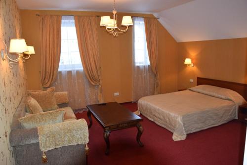a hotel room with a bed and a chair at Girele in Šiauliai