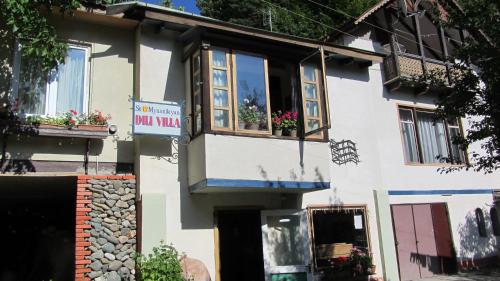 a white building with flowers in a window at Dili Villa in Dilijan