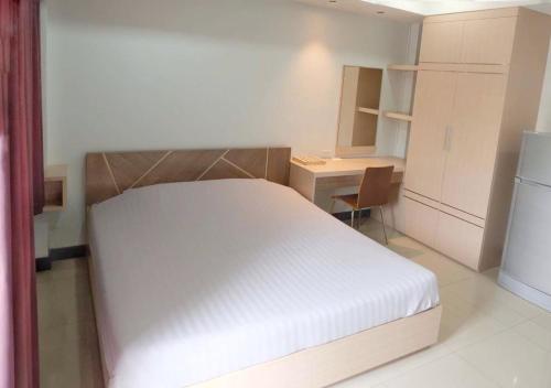 a bedroom with a bed and a desk and a refrigerator at Memory Place Samphran in Sam Phran