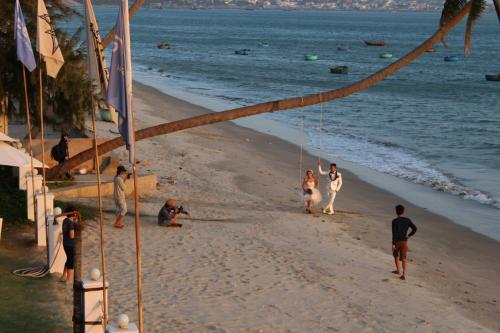 a group of people walking on the beach at Surf4You Residence in Mui Ne