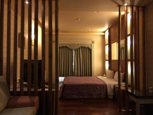 um quarto de hotel com uma cama e uma janela em ChangSing Business Motel em Tainan