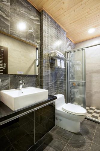 a bathroom with a white toilet and a sink at Iris Guest House in Hualien City