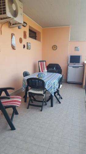 a room with a table and chairs and a kitchen at Casina Carina Carina in Nettuno