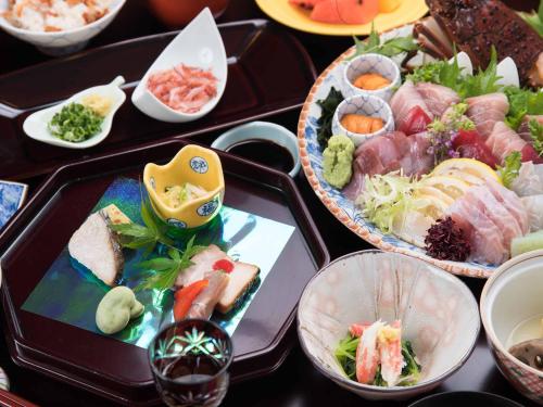 a table topped with trays filled with different types of food at Hotel Hagoromo in Shizuoka