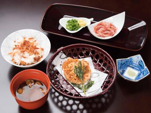 a table with a tray of food and bowls of food at Hotel Hagoromo in Shizuoka