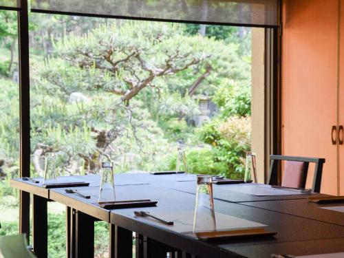 a table in a room with a large window at Hotel Hagoromo in Shizuoka
