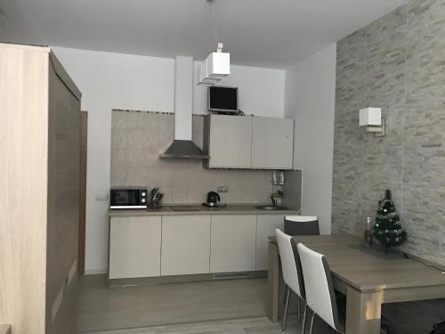 a kitchen with a table and a dining room at Taikos Apartmentai 2 in Druskininkai