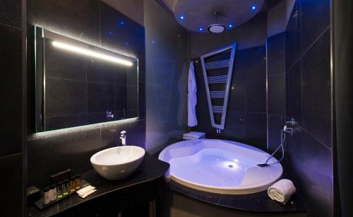 a black bathroom with a tub and a sink at Gatto Bianco Mia Aparthotel in Milan