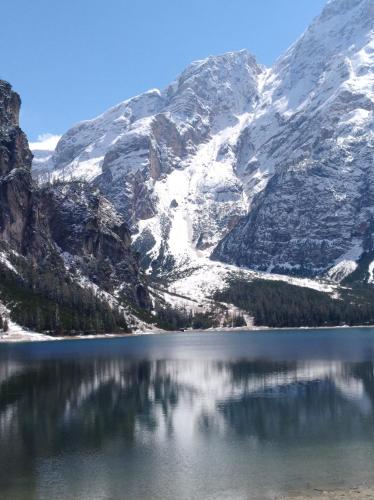 a mountain reflecting in a lake with snow at Sporthotel Rasen in Rasùn di Sotto