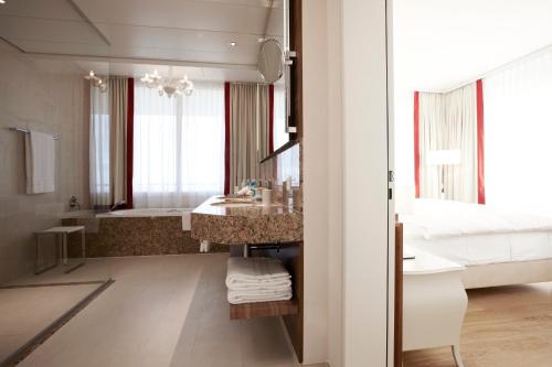 a bathroom with a sink and a large mirror at Oberwaid - Das Hotel. in St. Gallen