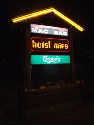 a sign for a hotel miregas at night at Hotel Mira in Sedrun