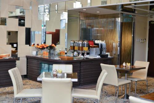 a restaurant with a bar with white chairs at Regal Hongkong Hotel in Hong Kong