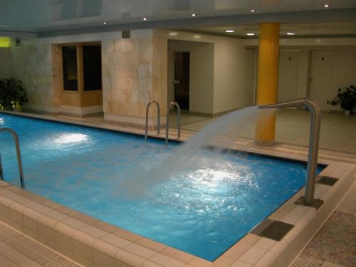 a pool with a water fountain in a building at Hotel Plinkšių in Plinkšės