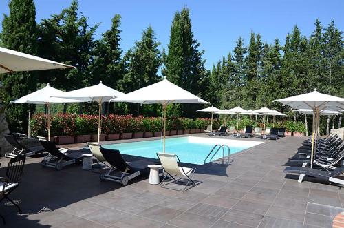 a pool with chairs and umbrellas and a group of chairs and tables at Casalta Di Pesa in Siena
