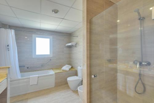 a bathroom with a shower and a toilet and a sink at Garden Playanatural - Adults Only in El Rompido
