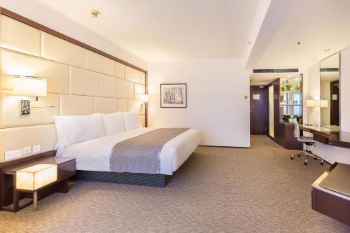 a hotel room with a bed and a desk at Regal Airport Hotel in Hong Kong