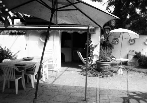 a patio with a table and an umbrella at Villa Maria Sole in Revello