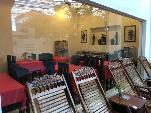 a restaurant with red tables and chairs and a window at King Boutique Hotel in Siem Reap